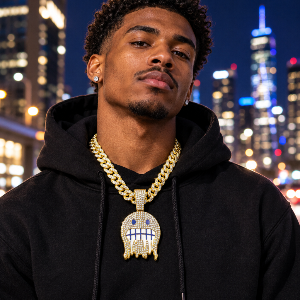 A confident young man wearing the iced rhinestone face pendant on a Cuban link chain over a black hoodie