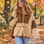A young woman wearing the color block sherpa half-button sweatshirt walking through a crisp autumn park